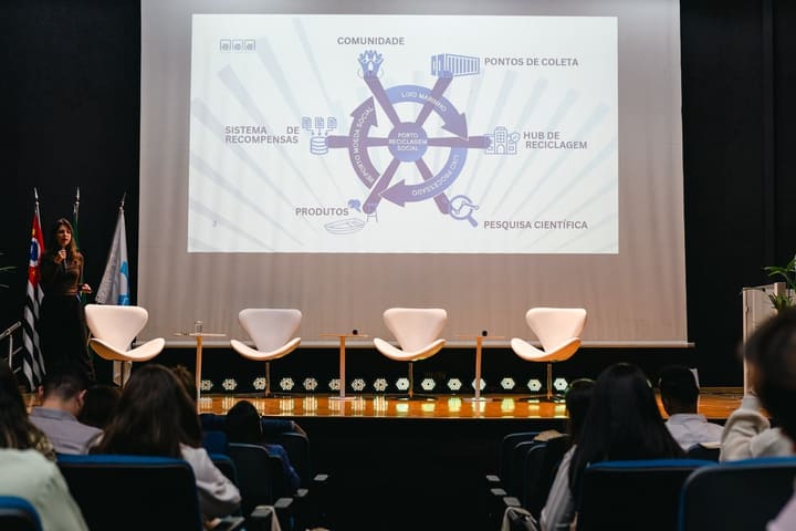 Apresentação do Porto Reciclagem Social no palco do II Fórum, com o mapa da rede no telão.