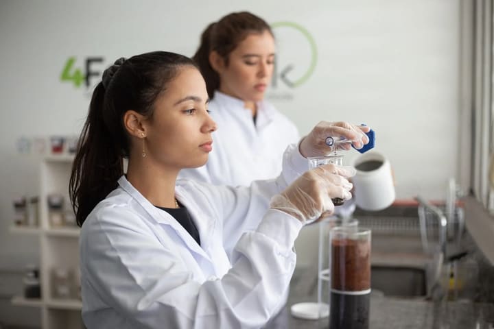 Duas pesquisadoras de jaleco fazem um ensaio no laboratório da 4Feedstock.