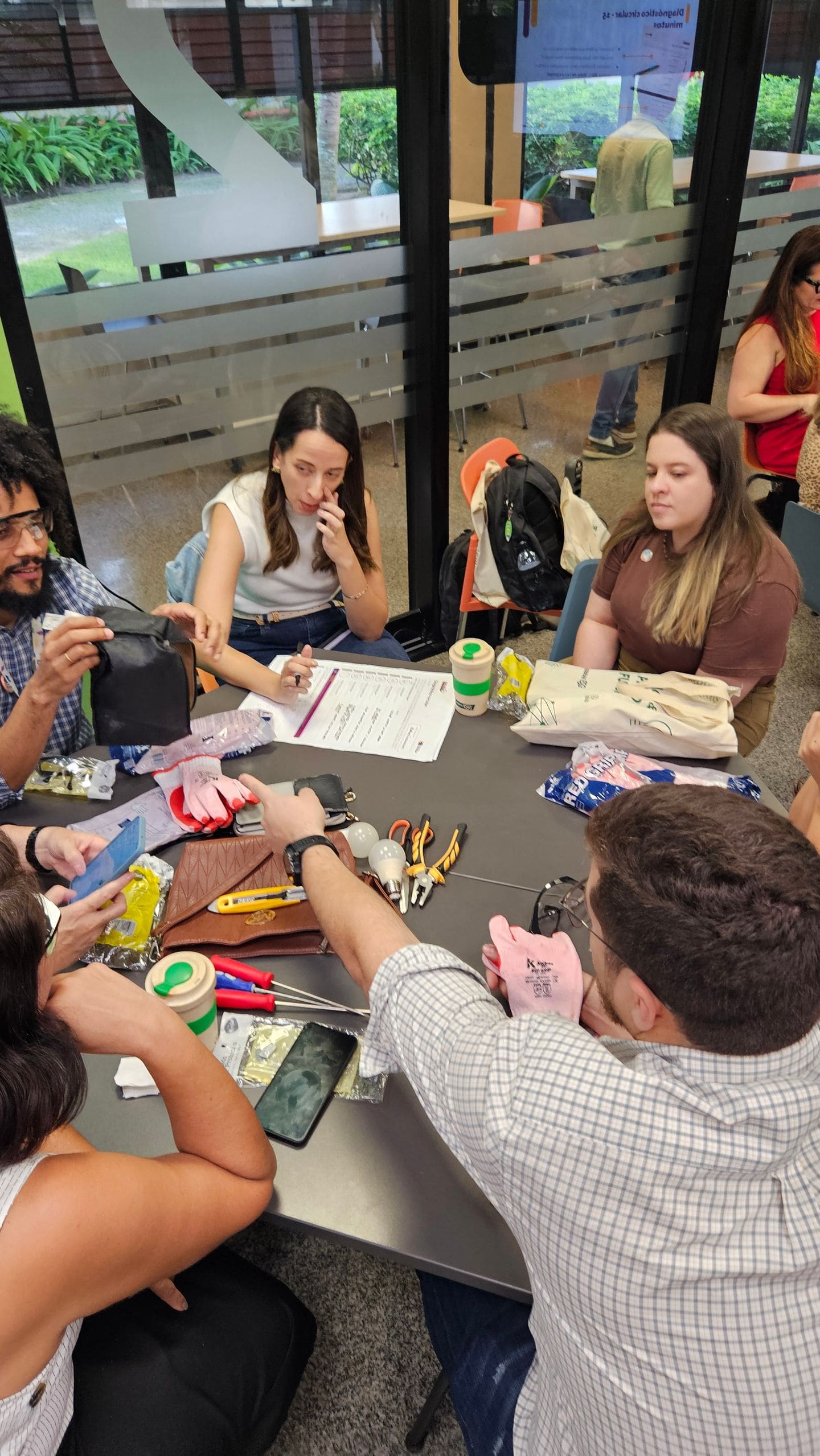 Participantes analisam materiais e ferramentas em uma atividade prática sobre Economia Circular